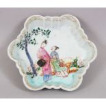 A 18TH CENTURY CHINESE FAMILLE ROSE PORCELAIN DISH / TEA POT STAND, depicting two figures within a