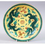 A CHINESE FAMILLE VERT PORCELAIN DRAGON DISH, a yellow ground with two green intertwined dragons,