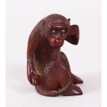 A GOOD JAPANESE MEIJI PERIOD CARVED WOOD NETSUKE OF A MONKEY, the monkey sat with his hand by his