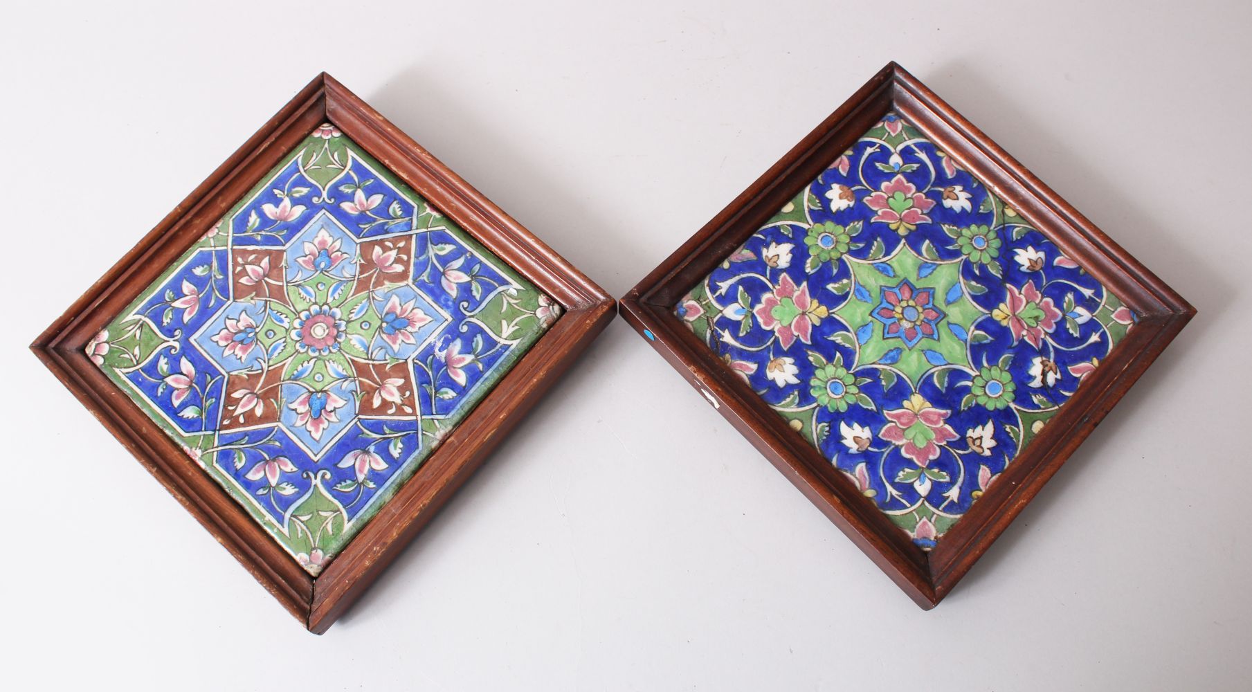 TWO PERSIAN QAJAR FRAMED POTTERY TILES.