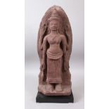 A 12TH CENTURY STYLE CAMBODIAN KHMER STYLE RED SANDSTONE CARVING OF A FOUR-ARMED DEITY. 52cms high.