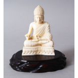 A 19TH CENTURY INDIAN CARVED IVORY BUDDHA, in a seated meditation position, on its hard wood