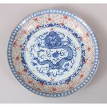 A 19TH CENTURY CHINESE BLUE & WHITE RICE PATTERN PORCELAIN DRAGON DISH, the base with a four-