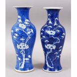 A NEAR PAIR OF 19TH CENTURY CHINESE BLUE & WHITIE PORCELAIN PRUNUS VASES, bases with double blue