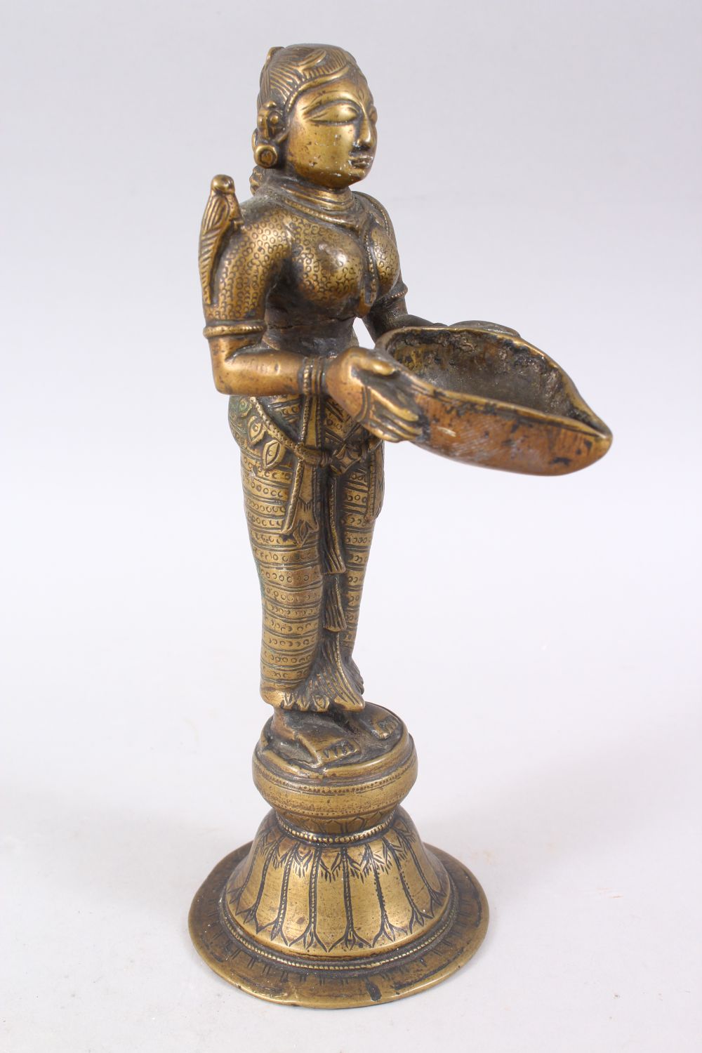 AN 18TH CENTURY INDIAN BRONZE OIL LAMP FIGURE OF LAKSHMI, stood on plinth holding a dish, 27cm - Image 2 of 6