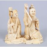 A JAPANESE MEIJI PERIOD CARVED IVORY OKIMONO OF TWO SCHOLARS, both in seated position wearing