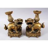 A PAIR OF 19TH / 20TH CENTURY CHINESE BRONZE CANDLESTICKS IN THE FORM OF LION DOGS, the pair of dogs