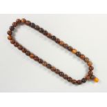 A 19TH CENTURY QING DYNASTY CHINESE RHINOCEROS HORN & AMBER ROSARY BEADS / NECKLACE, comprising of