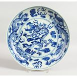 A CHINESE BLUE AND WHITE CIRCULAR DISH with dragon design. Six-character mark on base. 10.5ins