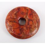 A GOOD 19TH / 20TH CENTURY CHINESE CARVED JADE RUSSET CHILONG BI DISK, 6cm diameter.