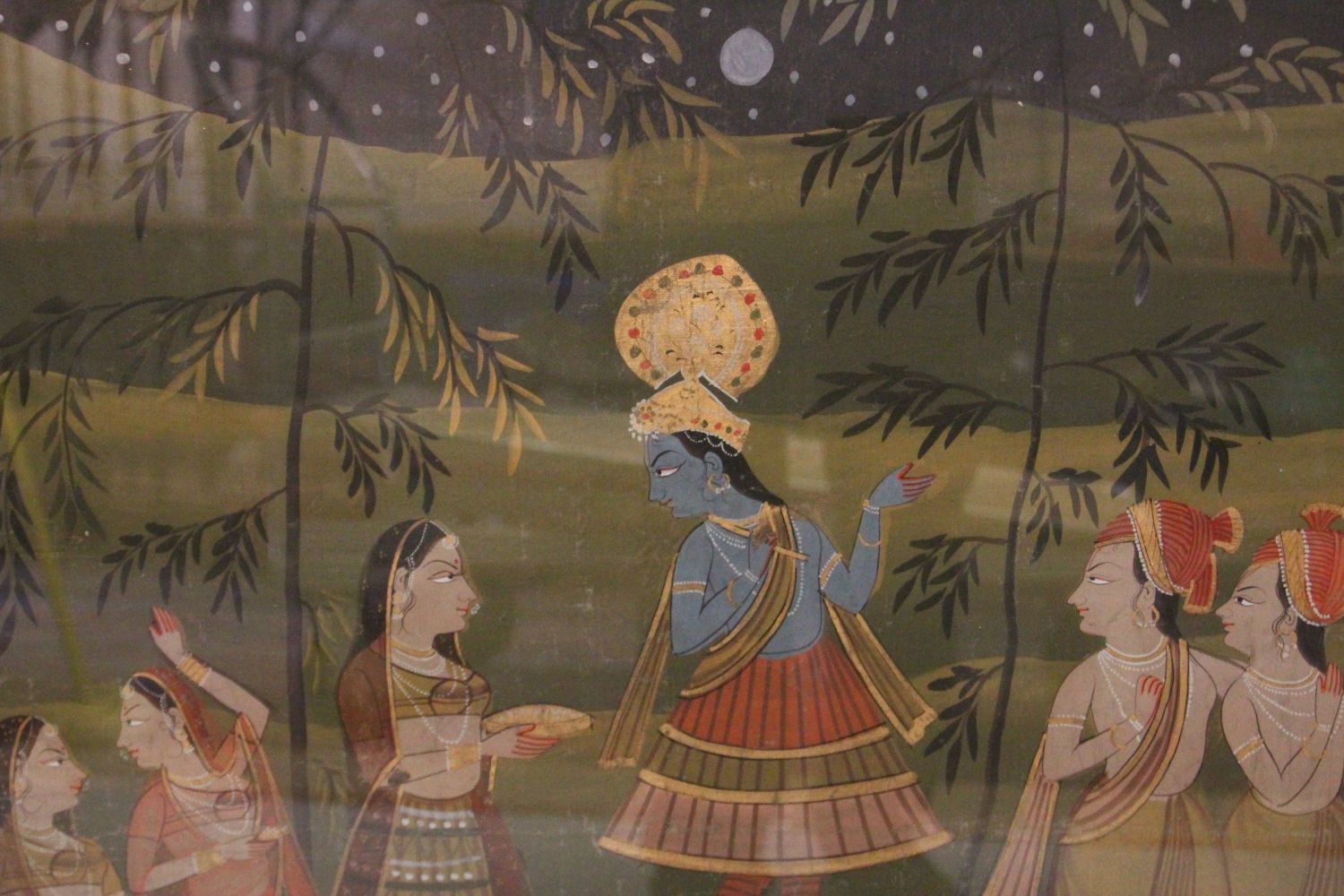 A 19TH-20TH CENTURY FRAMED INDIAN PAINTING ON TEXTILE depicting a blue skin god stood amongst - Image 2 of 2