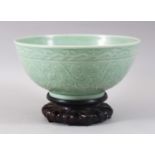 A GOOD CHINESE CELADON CARVED BOWL & HARDWOOD STAND, the bowl carved with formal scrolling lotus and