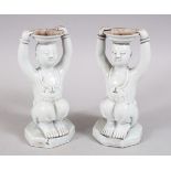 PAIR OF CHINESE BLANC DE CHINE PORCELAIN CANDLESTICKS OF BOYS, in a seated position holding a tray