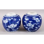 A NEAR PAIR OF EARLY 20TH CENTURY CHINESE BLUE & WHITE PORCELAIN PRUNUS JARS, the bases with