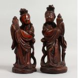 A PAIR OF 19TH CENTURY CHINESE CARVED WOOD FIGURES. 8.5ins high.