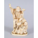 A JAPANESE MEIJI PERIOD CARVED IVORY OKIMONO OF MAN & BOY, the man stood holding his hand aloft