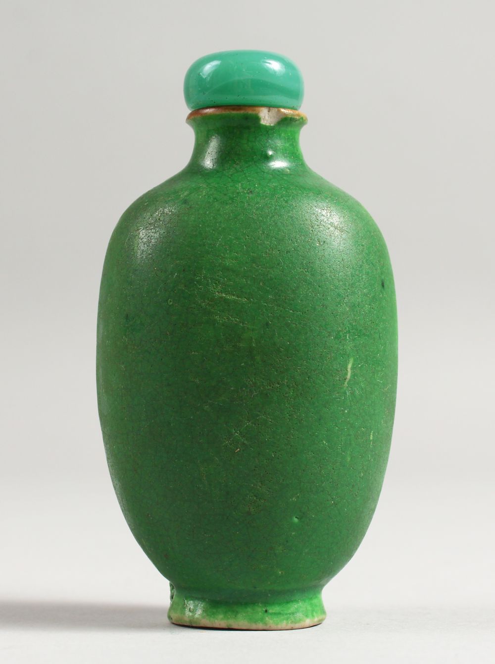 A CHINESE GREEN GROUND PORCELAIN SNUFF BOTTLE AND STOPPER, 8.5CM.