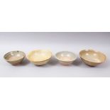 FOUR EARLY CHINESE POTTERY GLAZED BOWLS, some glazed, some partially glazed, various sized but