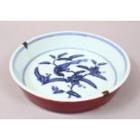 A CHINESE MING STYLE BLUE & WHITE / SANG DE BOEUF PORCELAIN DISH, the centre of the dish decorated