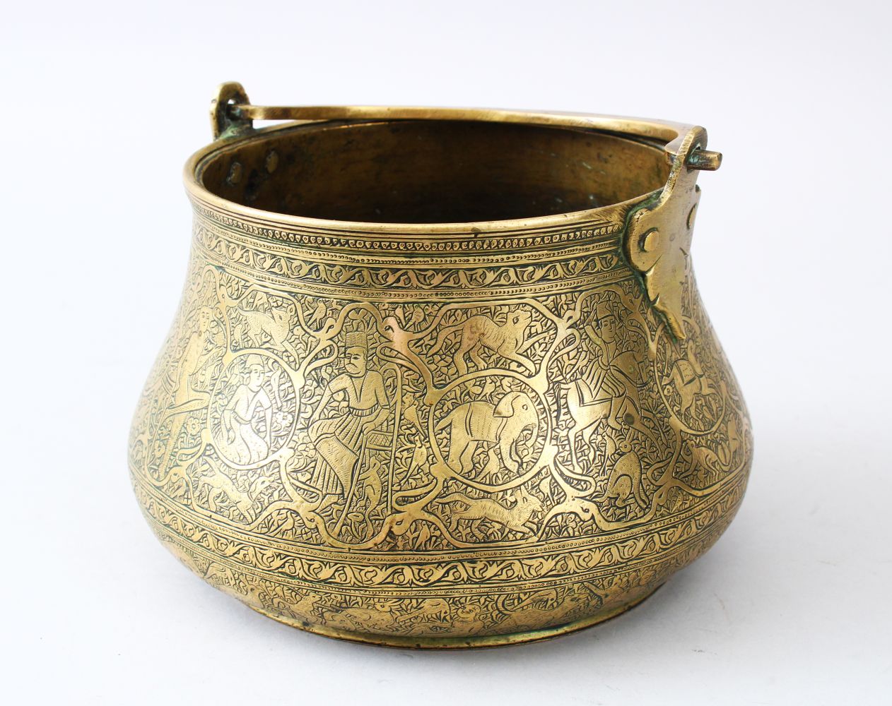 A VERY FINE 18TH/19TH CENTURY QAJAR HAND CHASED BRASS BOWL WITH SWING HANDLE, the body engraved with