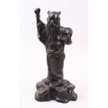 A LATE 19TH CENTURY CHINESE BRONZE FIGURE OF AN IMMORTAL / SCHOLAR, stood upon a rock formed base