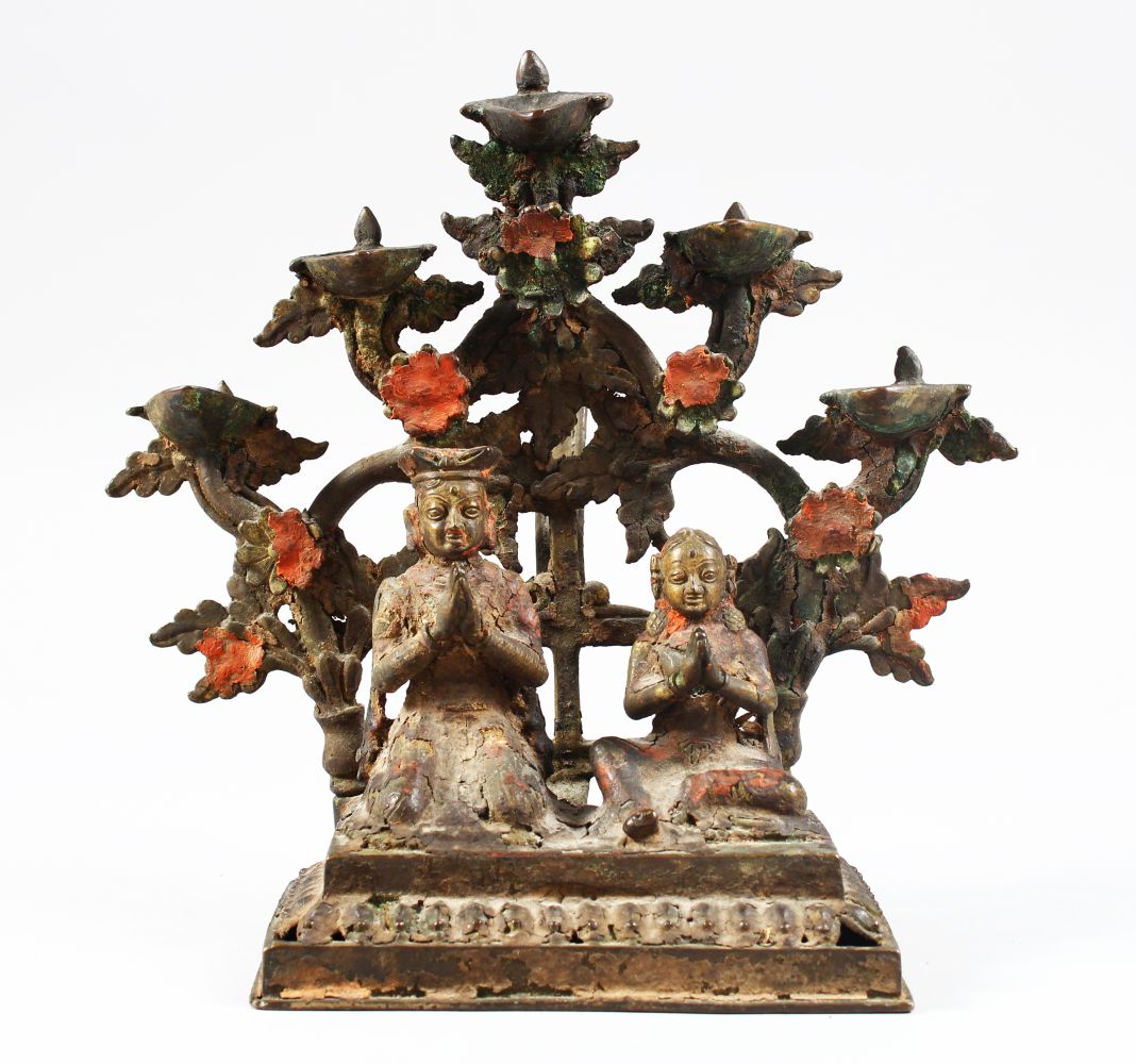 A FINE 18TH / 19TH CENTURY INDIAN OR NEPALESE BRONZE OIL LAMP, of a seated couple with five oil