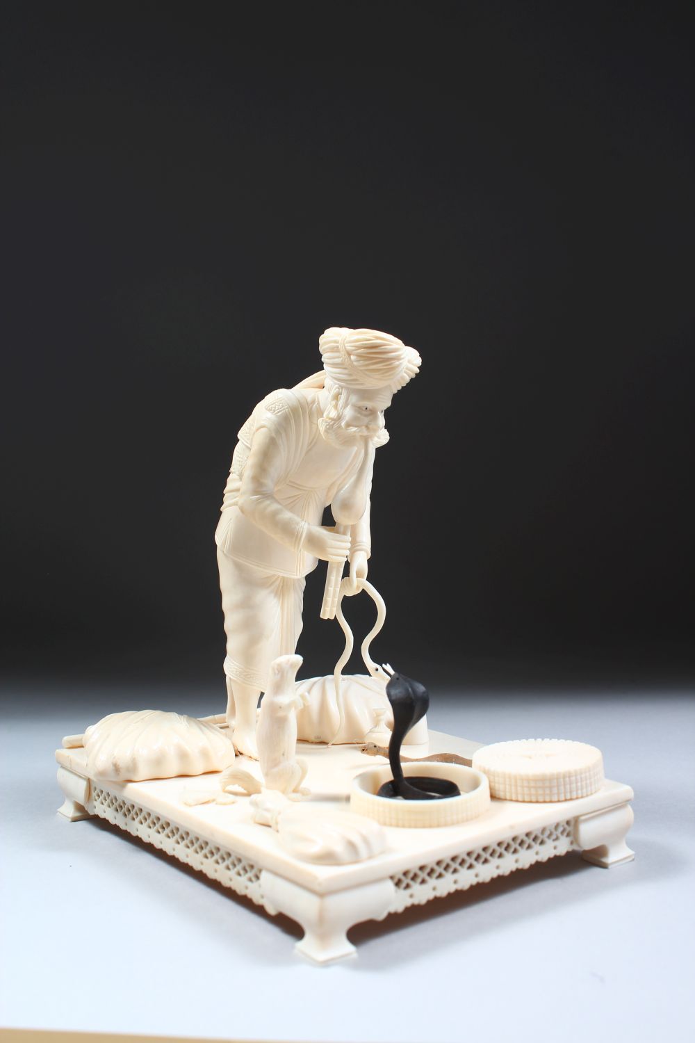 A 19TH CENTURY CARVED INDIAN IVORY MODEL OF A SNAKE CHARMER, the man stood over two snakes with a - Image 2 of 8