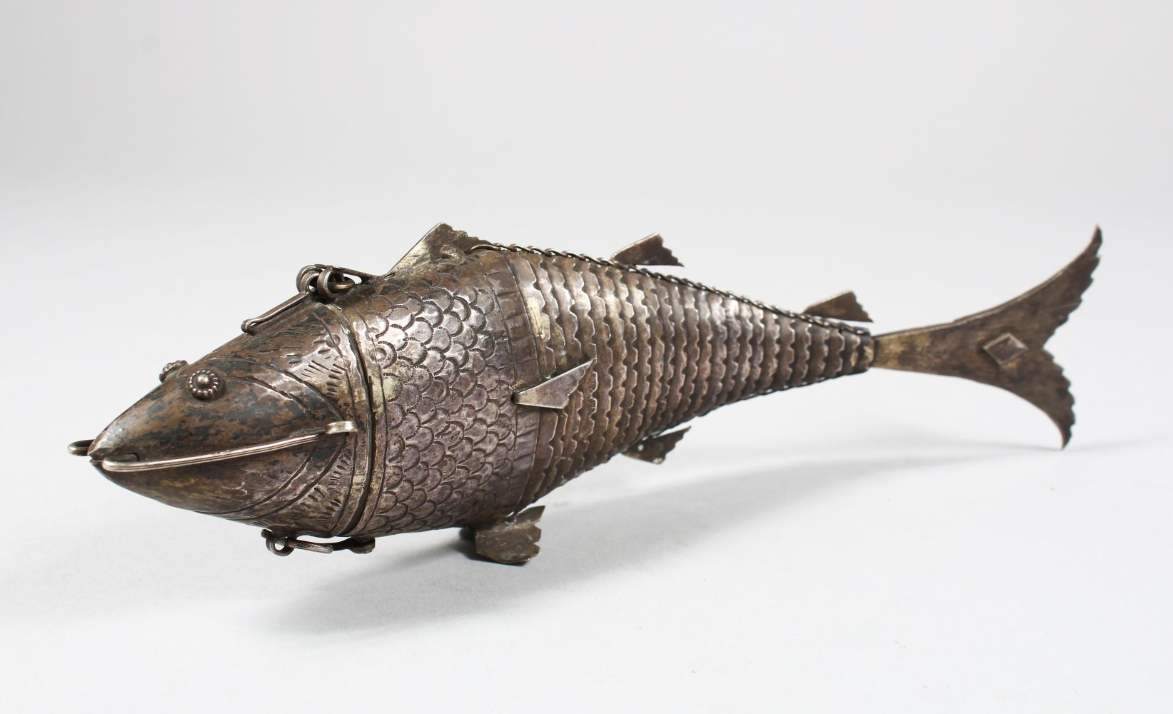 A 19TH CENTURY INDIAN SILVER RETICULATED FISH SHAPED SPICE BOX, the head opening, 25cm long