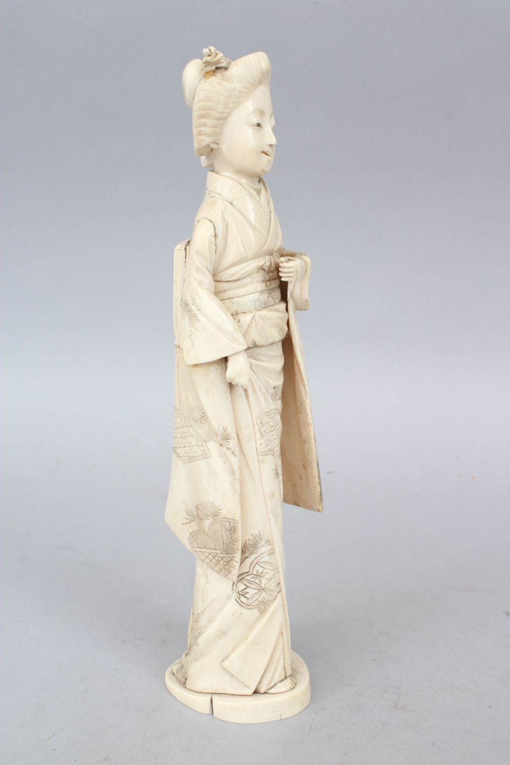 A JAPANESE MEIJI PERIOD CARVED IVORY OKIMONO OF A GEISHA GIRL, the lady stood holding some - Image 2 of 6