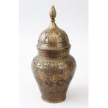 A 19TH CENTURY PERSIAN QAJAR ISLAMIC BRASS JAR AND COVER, with pierced and engraved decoration, 25cm