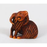 A JAPANESE MEIJI PERIOD CARVED WOODEN NETSUKE OF A GOAT AFTER MITSUHARU, the goat in a recumbent