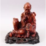 A GOOD 19TH CENTURY CHINESE CARVED WOOD FIGURE OF A SAGE, seated reading from his scroll / book,