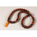 A 19TH CENTURY QING DYNASTY CHINESE RHINOCEROS HORN & AMBER ROSARY BEADS / NECKLACE , comprising