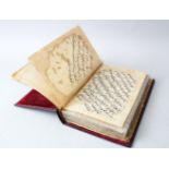 A GILT BOUND LEATHER ISLAMIC PRAYER BOOK, 23cm x 14cm.