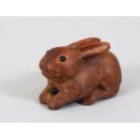 A JAPANESE MEIJI PERIOD CARVED WOODEN NETSUKE OF A RABBIT, in a recumbent position, the eyes