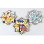 THREE ISLAMIC STAR SHAPED CERAMIC TILES, painted with birds, 17cm wide (3).