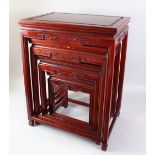 A NEST OF 20TH CENTURY CHINESE HARDWOOD TABLES, rectangular top with a carved frieze on four moulded