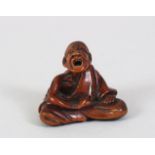 A JAPANESE EDO PERIOD CARVED BOXWOOD NETSUKE OF A SCRATCHER MAN, the man in a seated position with