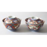A PAIR OF JAPANESE MEIJI PERIOD IMARI PORCELAIN BOWLS AND COVERS, painted with alternating panels of