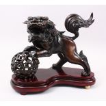 A GOOD 19TH / 20TH CENTURY CHINESE BRONZE FIGURE OF A LION DOG / KYLIN & BALL, the dog with its paws