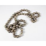 A LONG STRAND OF 19TH CENTURY TURKMAN SILVER BEADS, consisting of 70 spherical beads with gilded