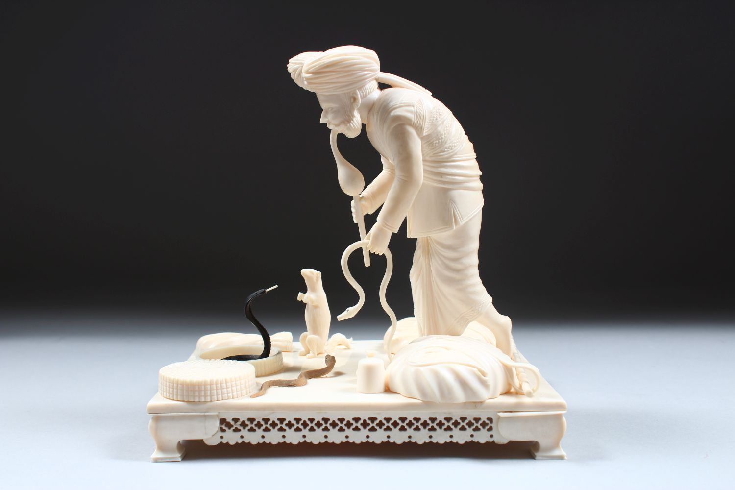 A 19TH CENTURY CARVED INDIAN IVORY MODEL OF A SNAKE CHARMER, the man stood over two snakes with a - Image 5 of 8