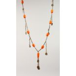 A CHINESE CARVED AMBER BEAD AND WHITE METAL NECKLACE, 104CM LONG.