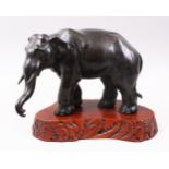 A JAPANESE MEIJI PERIOD BRONZE ELEPHANT OKIMONO - ARTIST SIGNED, the elephant in relaxed a pose,