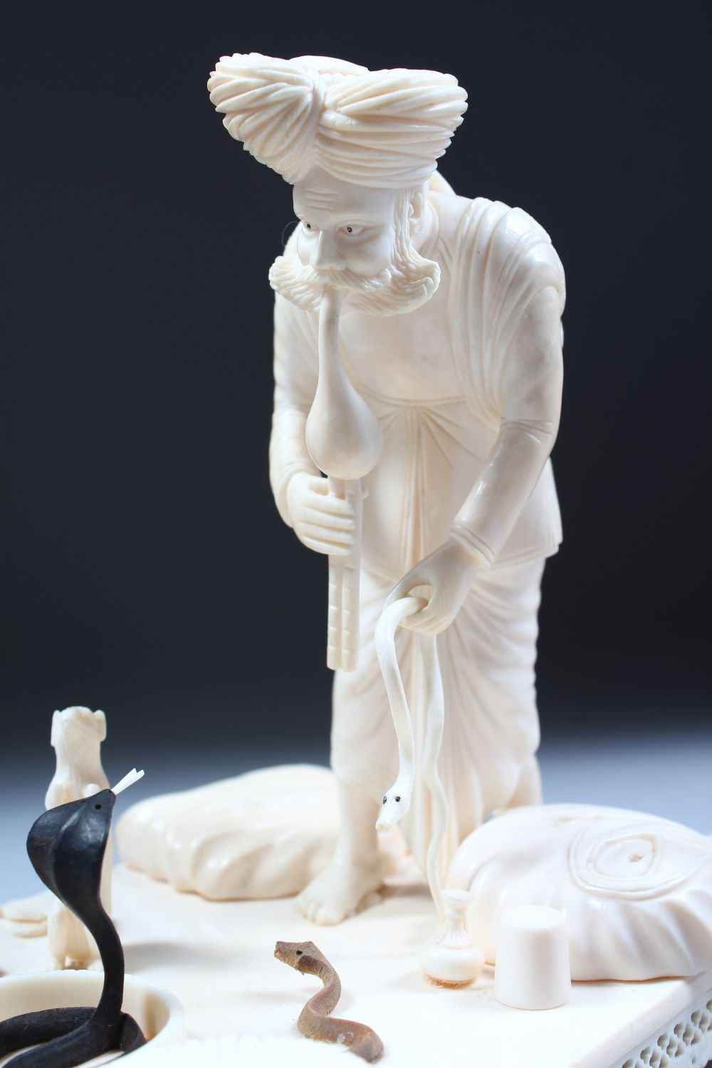 A 19TH CENTURY CARVED INDIAN IVORY MODEL OF A SNAKE CHARMER, the man stood over two snakes with a - Image 6 of 8