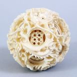 A GOOD 19TH CENTURY CHINESE CARVED IVORY PUZZLE BALL, carved to depict dragons amongst flora, 6.