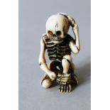 A JAPANESE MEIJI PERIOD CARVED IVORY NETSUKE OF A SKELETON, the skeleton in a seated position with