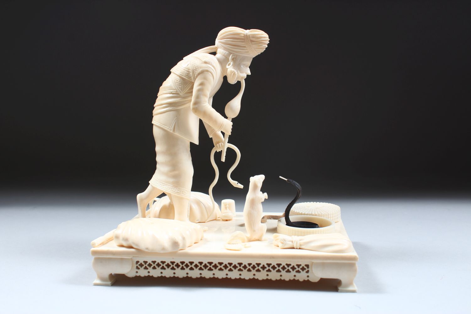 A 19TH CENTURY CARVED INDIAN IVORY MODEL OF A SNAKE CHARMER, the man stood over two snakes with a - Image 3 of 8