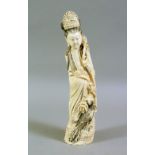 AN EARLY 20TH CENTURY CHINESE CARVED IVORY FIGURE, of a young lady standing with a bird by her side,