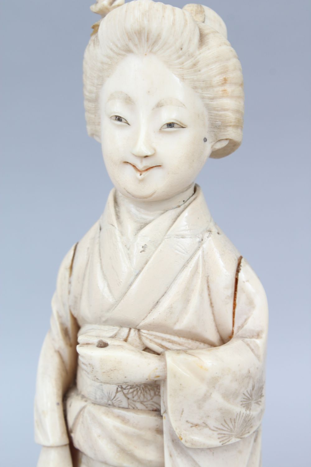 A JAPANESE MEIJI PERIOD CARVED IVORY OKIMONO OF A GEISHA GIRL, the lady stood holding some - Image 4 of 6